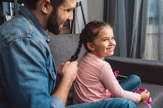 Parent braiding child's hair