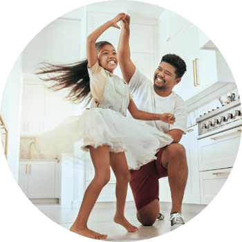 Father and daughter dancing in kitchen